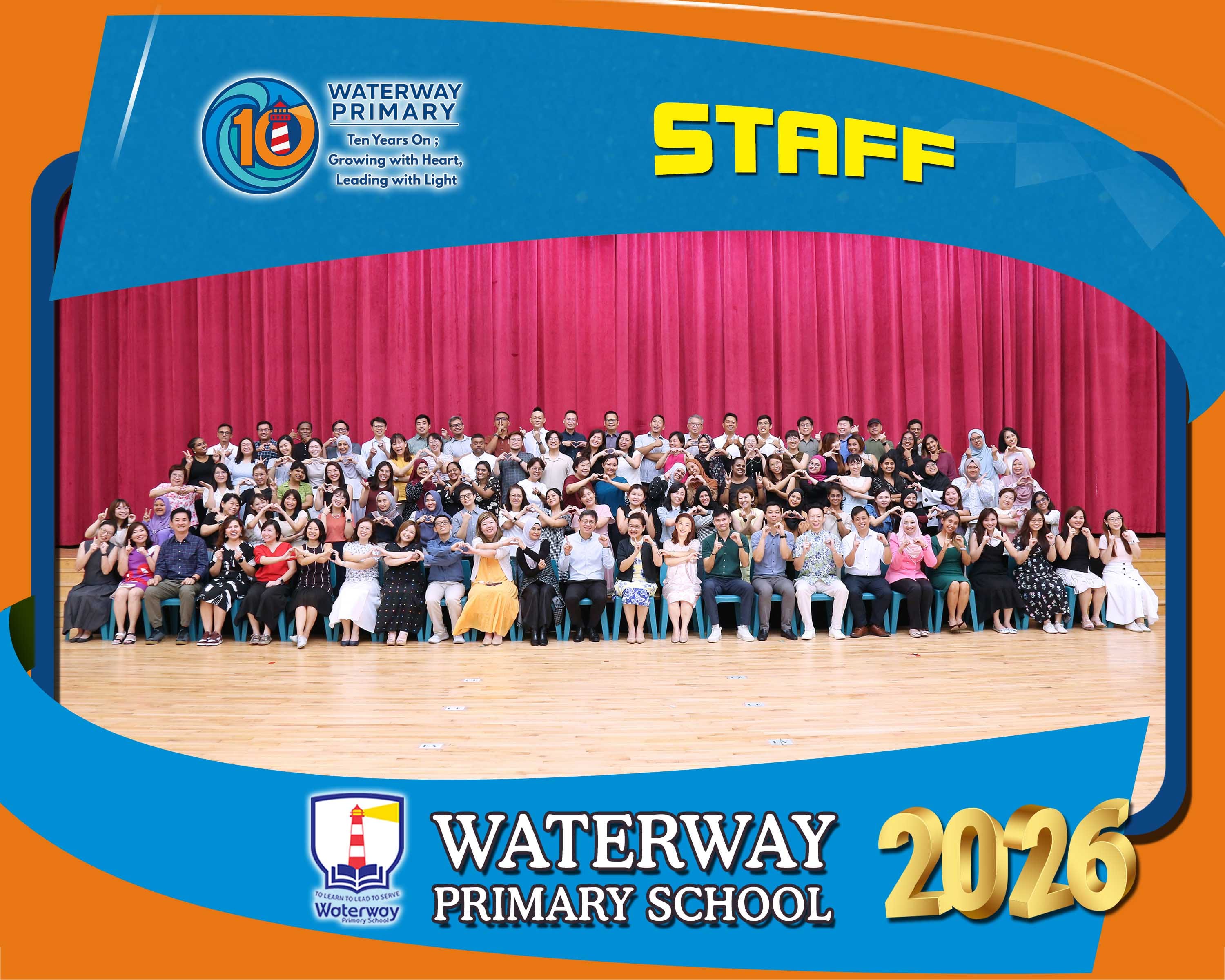 Waterway Primary School 2026 staff group photo with many people posing with heart hand gestures on a stage.